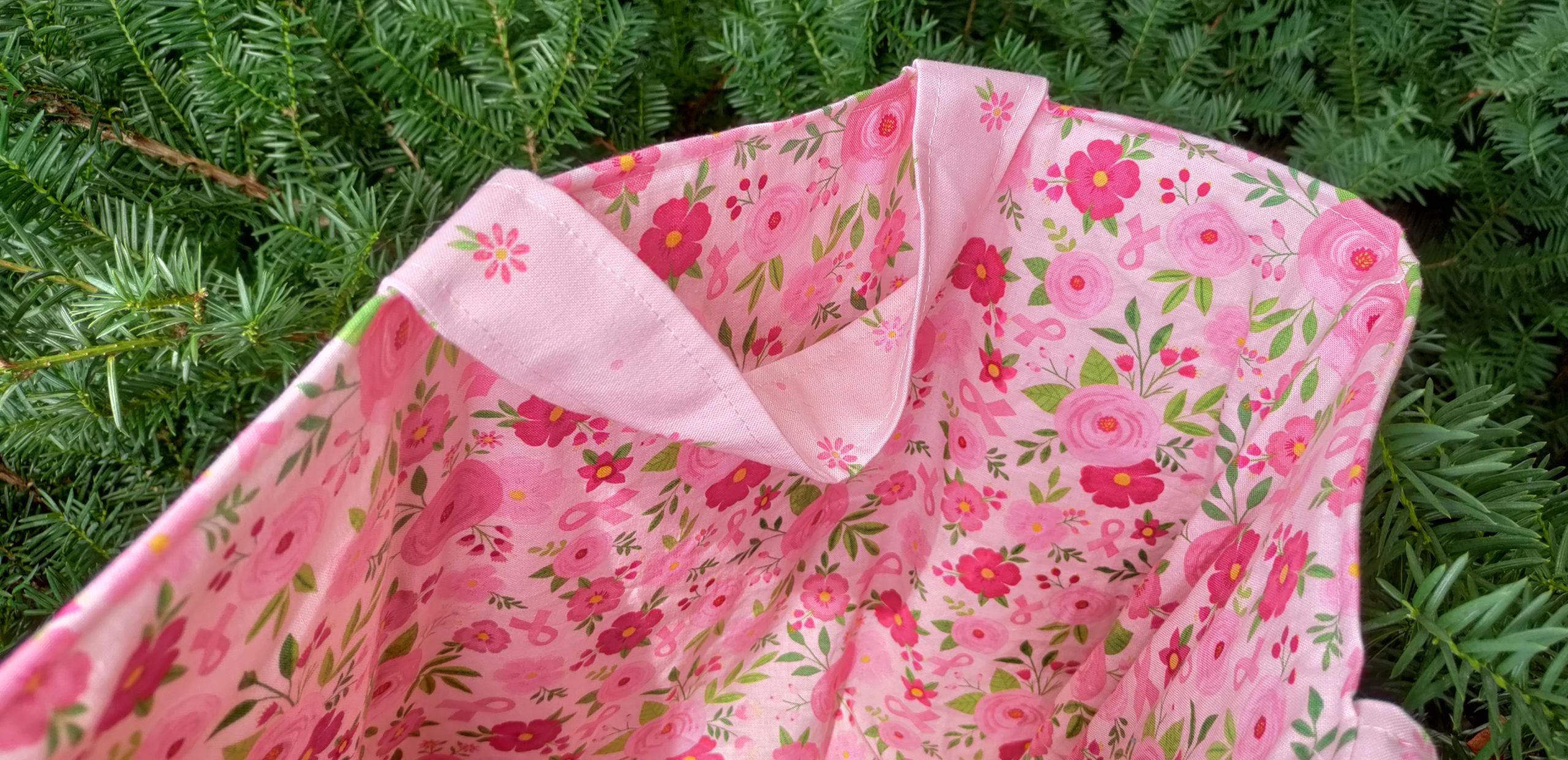 I used the Strength in Pink fabric collection, which features various shades of pink with butterflies, flowers, and breast cancer ribbons, to make a tote bag with several pockets on the outside.